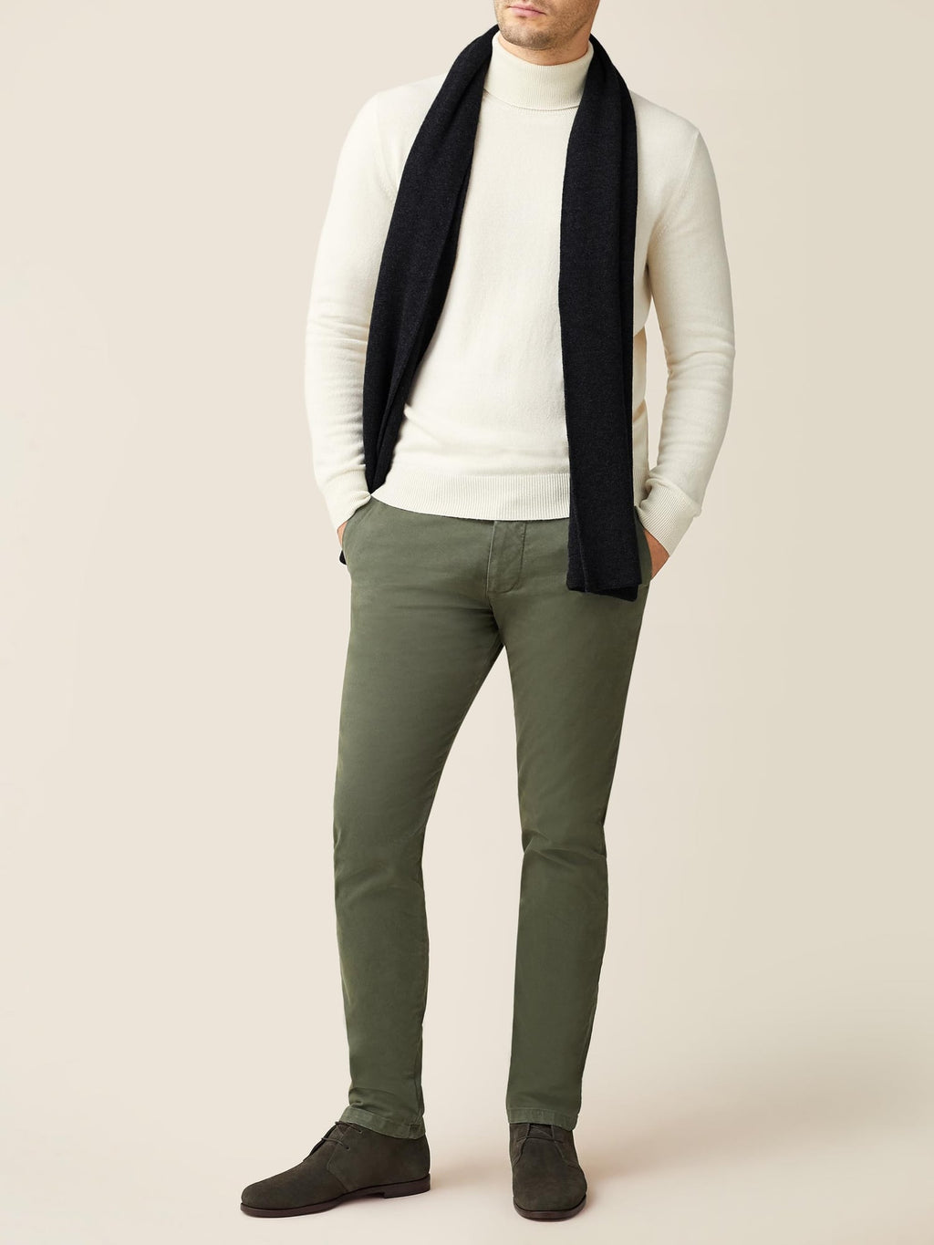 Front view of a model wearing the Luca Faloni Black Cashmere Scarf with a cream turtleneck and olive trousers.