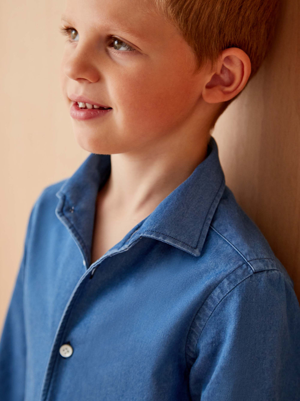 Close-up of a boy wearing the Classic Blue Denim Junior Linen Shirt, highlighting the one-piece collar.