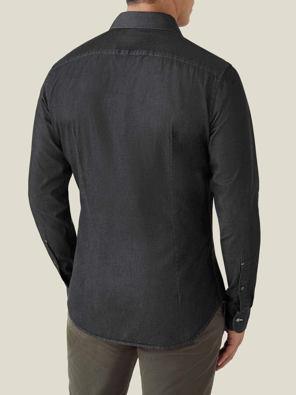 A man models the back of the Luca Faloni Black Denim Shirt, showing its tailored fit.