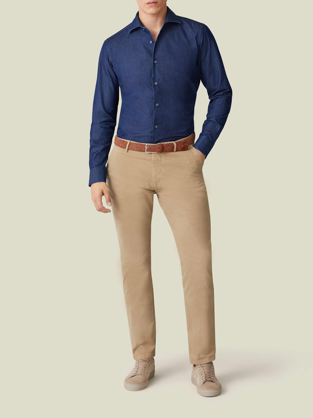 Model wears the Luca Faloni Denim Shirt in Midnight Blue, tucked into beige chinos with a brown woven belt.