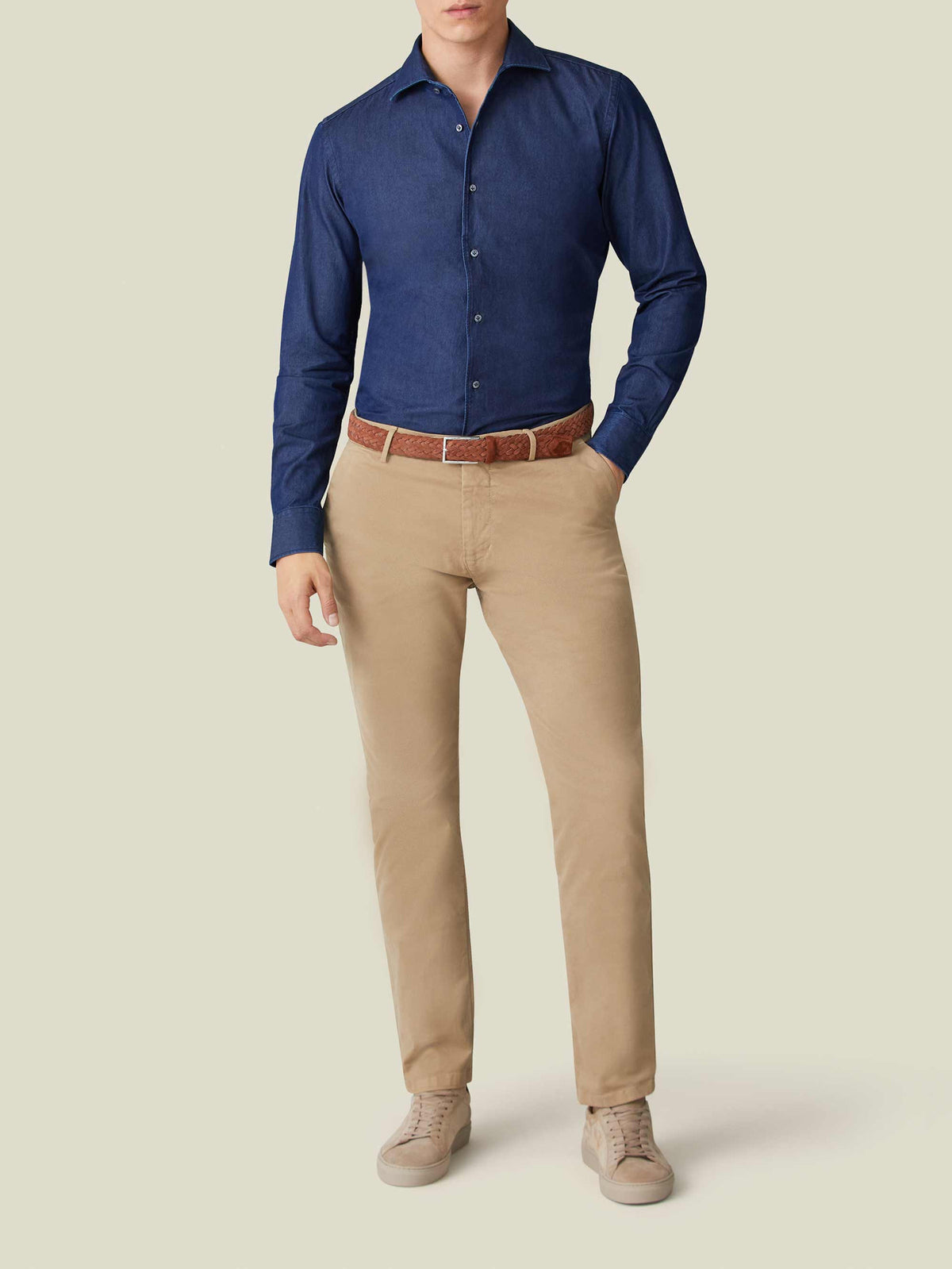 Model wears the Luca Faloni Denim Shirt in Midnight Blue, tucked into beige chinos with a brown woven belt.
