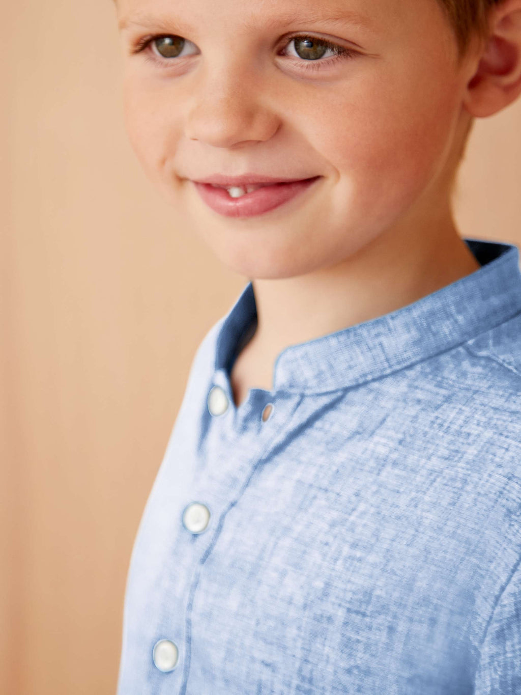 Close-up of a boy wearing the sky blue Forte Junior linen shirt, highlighting the band collar and fabric texture.