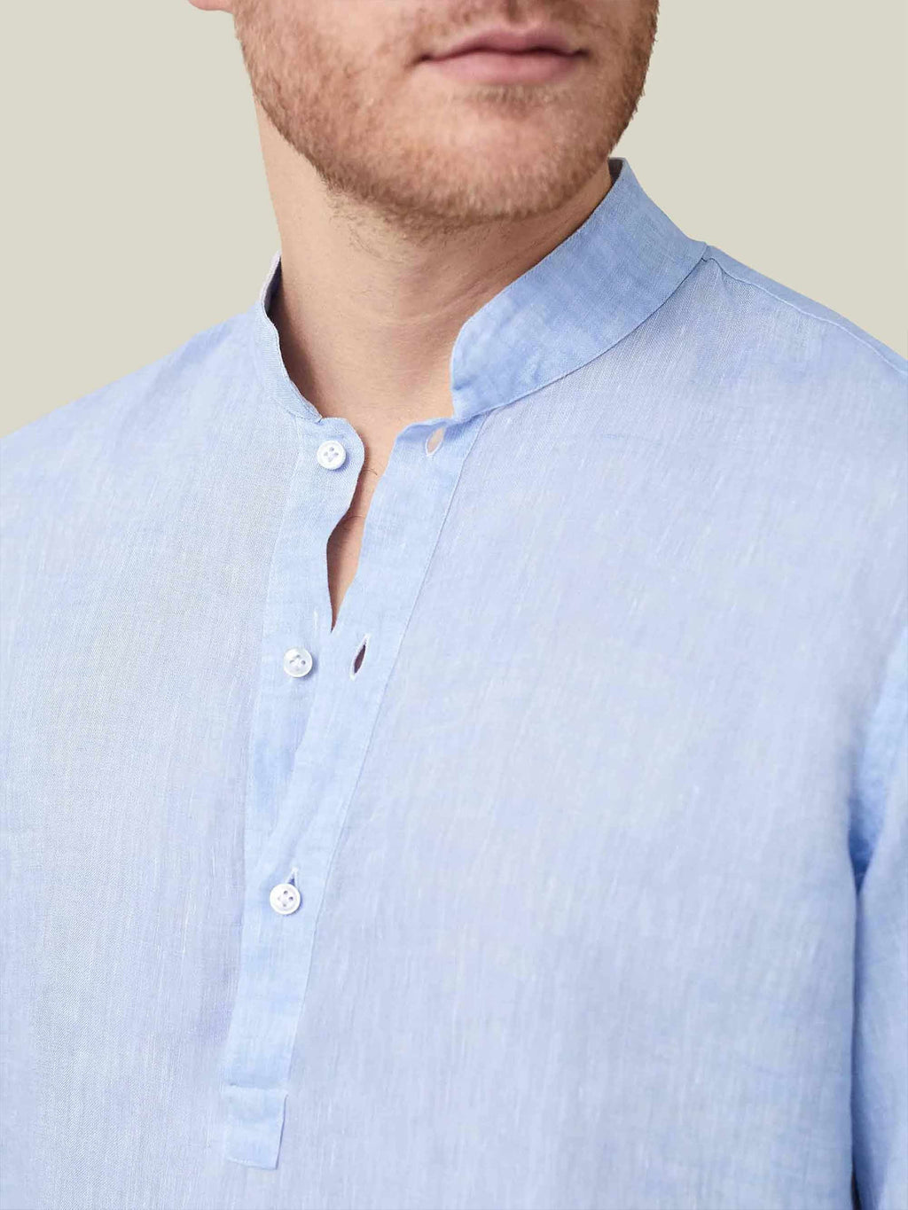 Close-up of a man wearing the sky blue Forte Linen Shirt, focusing on the detail of the band collar and button placket.