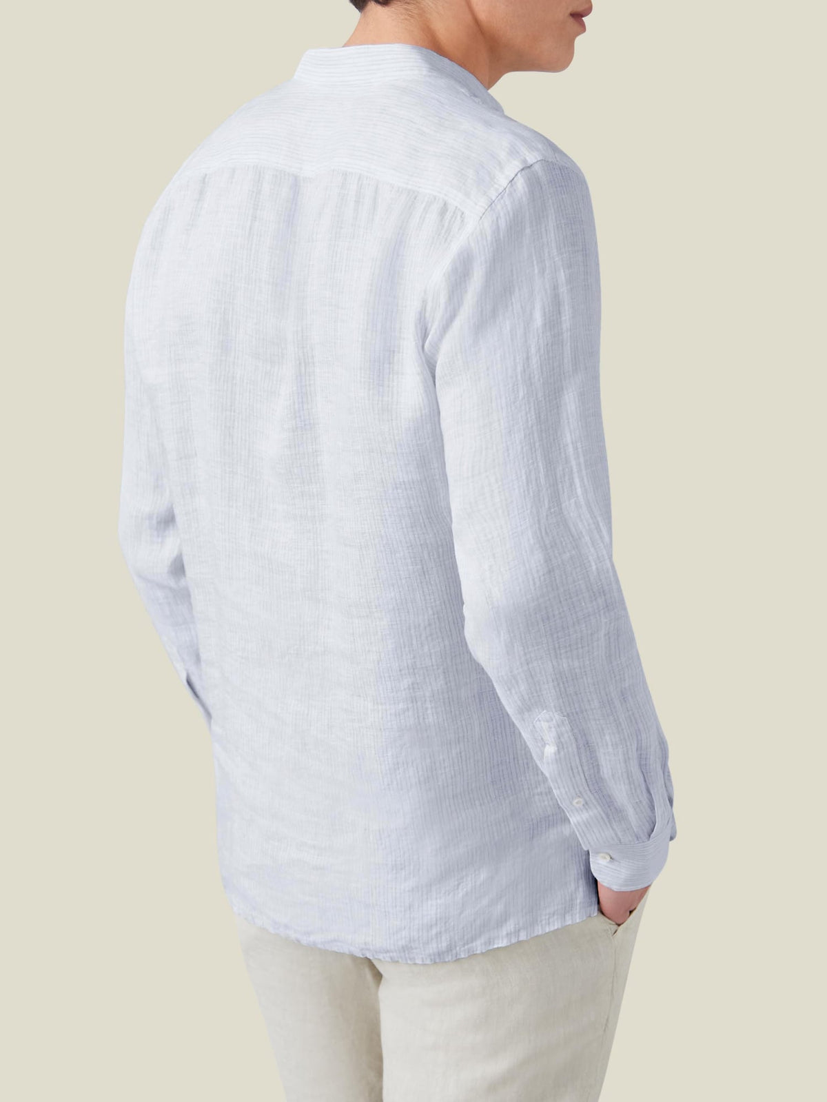 Back view of a model wearing the Luca Faloni Forte Linen Shirt in Thin Striped, styled with light-coloured trousers.