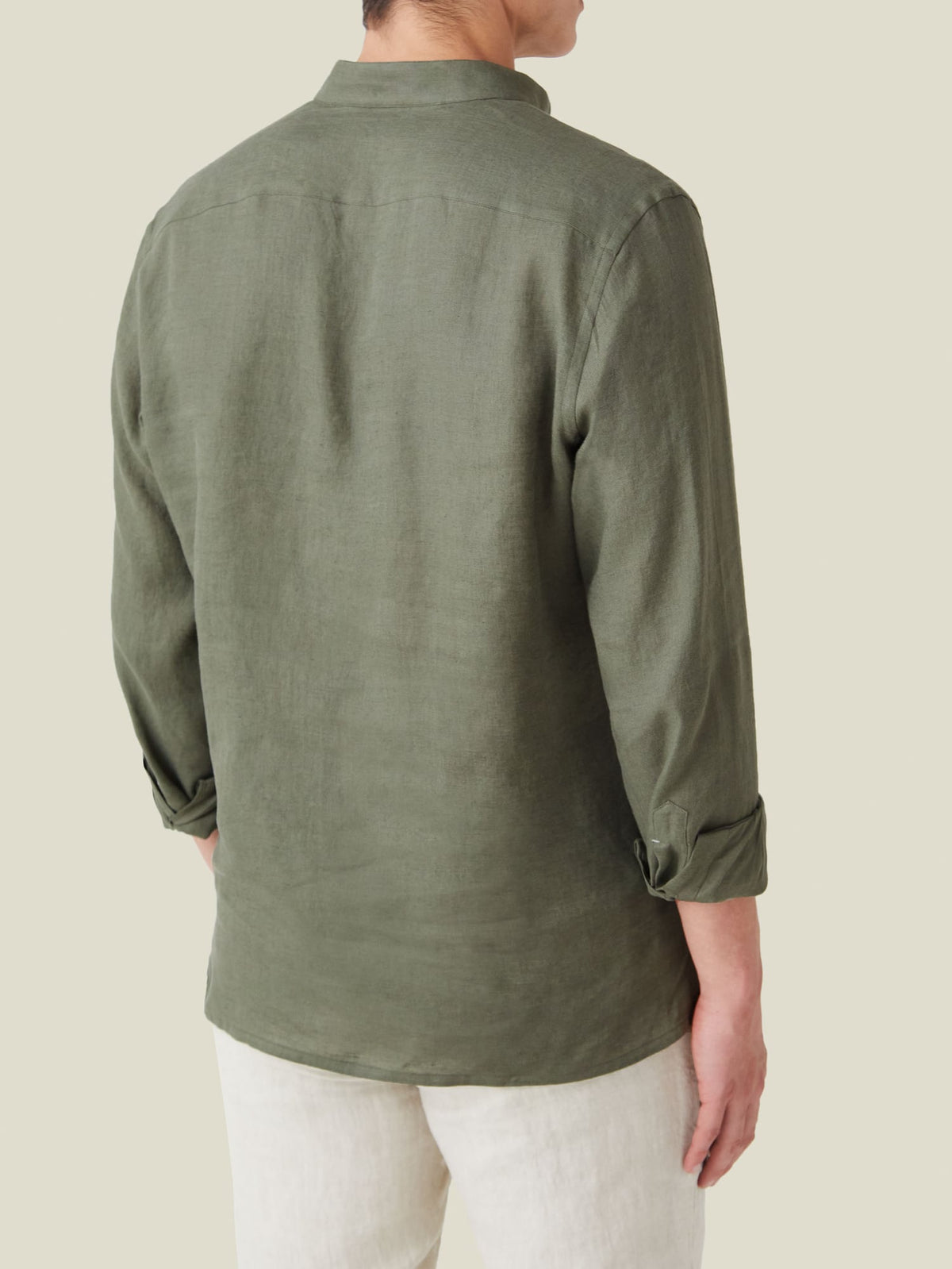Rear view of a model wearing the Forte Linen Shirt in Khaki Green with sleeves rolled up.