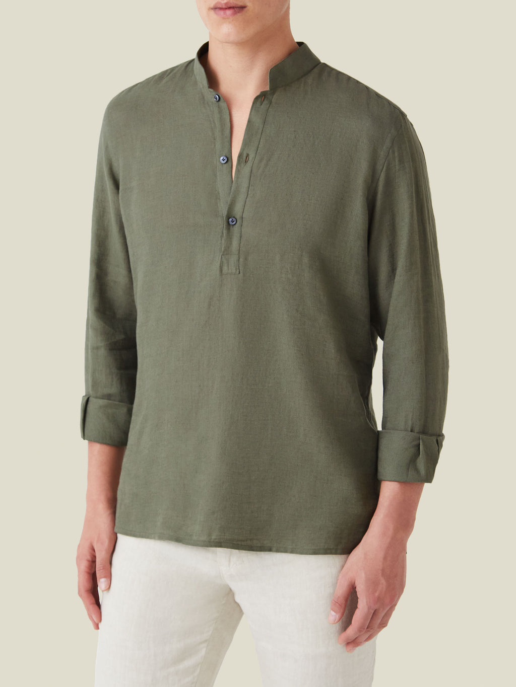 Front view of a model wearing the Forte Linen Shirt in Khaki Green, showcasing its band collar and rolled-up sleeves.