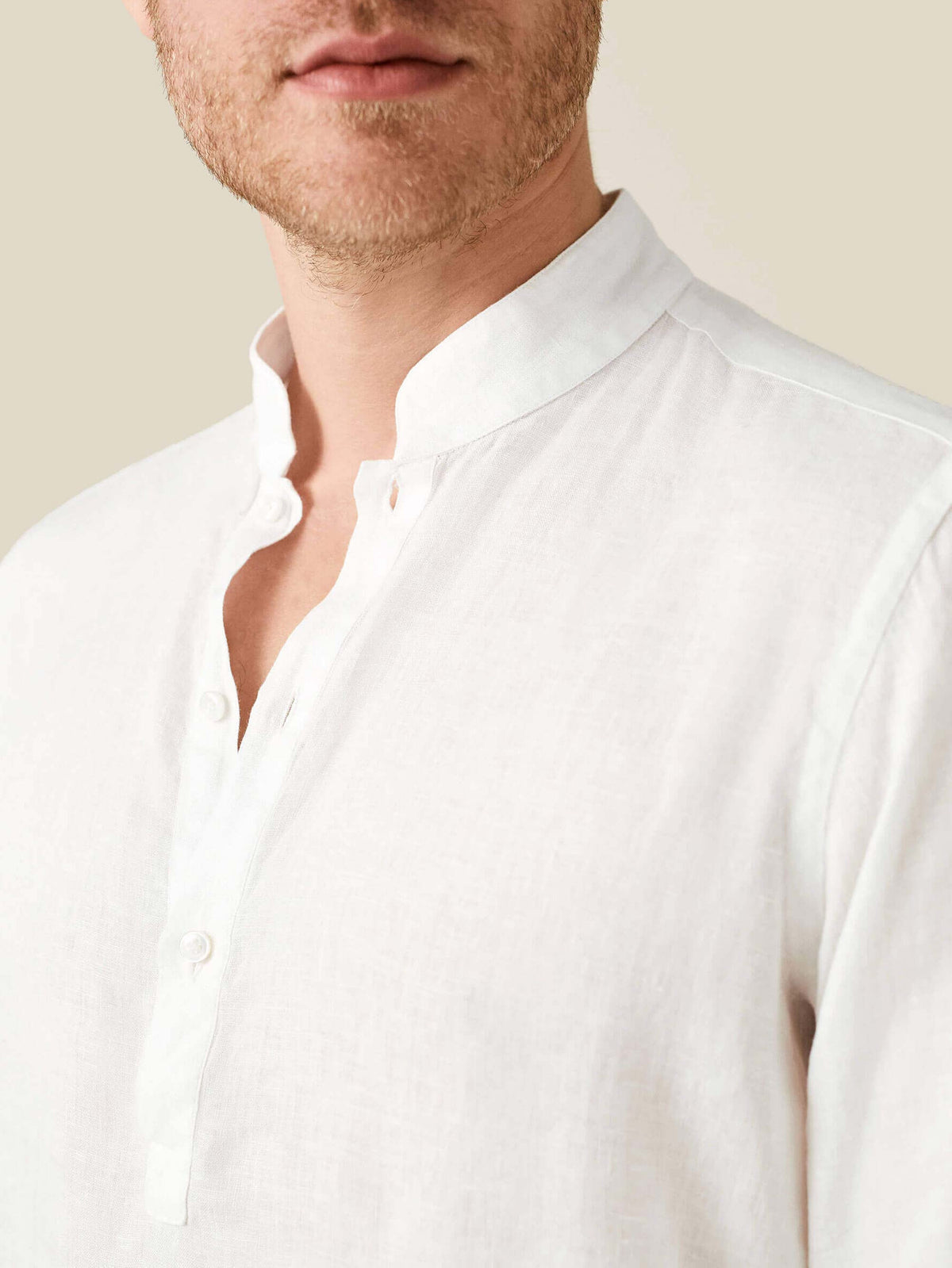 Close-up of a man wearing the white Forte Linen Shirt, showing the texture of the fabric and the details of the band collar.