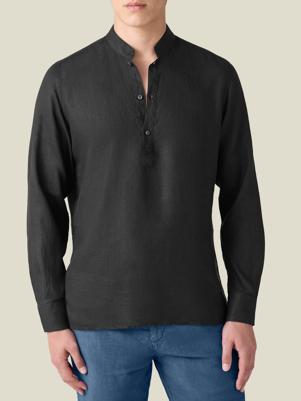 Front-facing view of a model wearing the black Forte Linen Shirt, a popover style with a band collar.