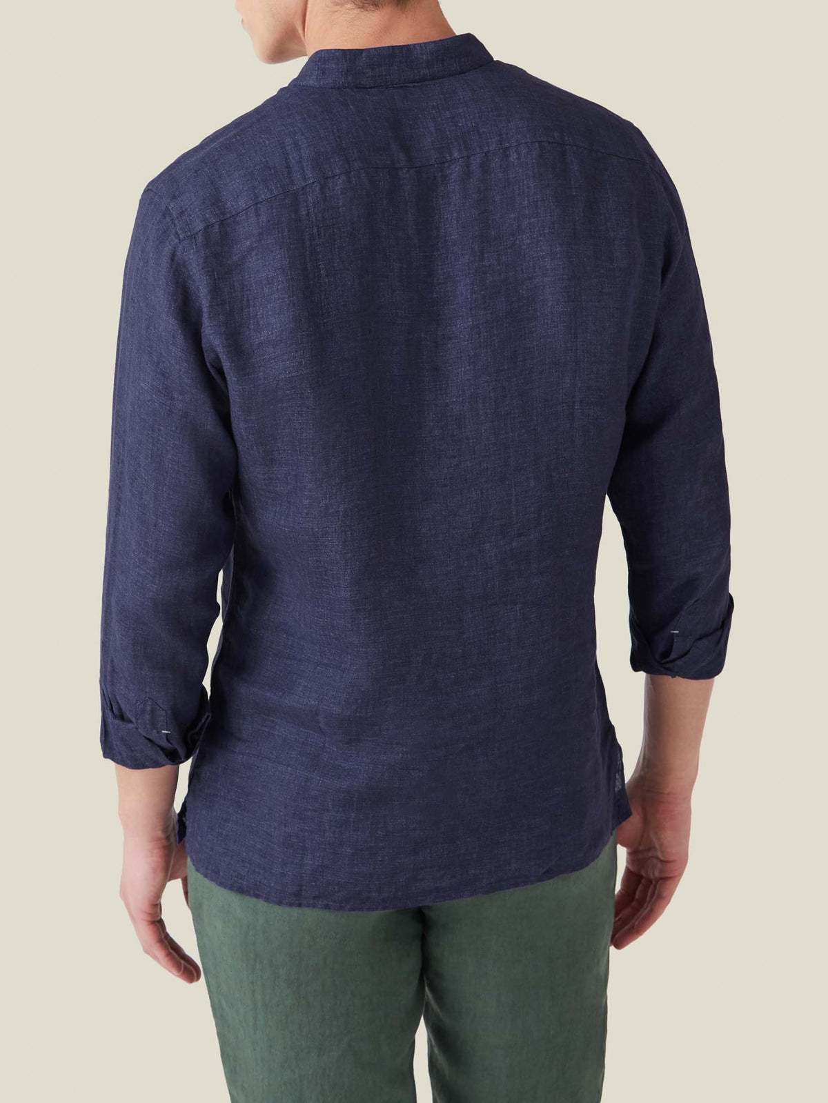Back view of a model wearing the Forte Linen Shirt in navy blue with sleeves rolled up.