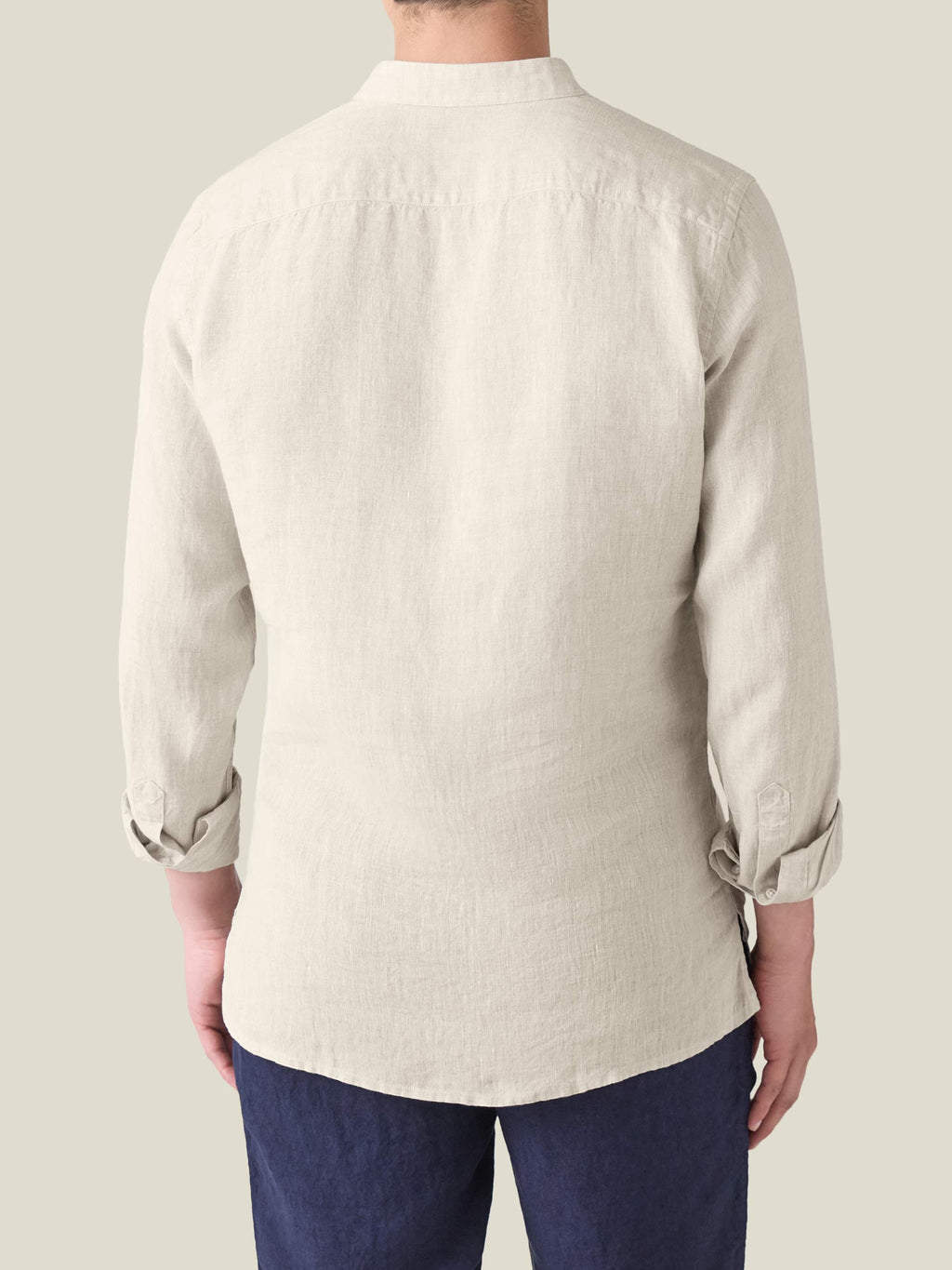 Rear view of the Forte Linen Shirt in sand, showing the relaxed fit, back yoke, and rolled-up sleeves.