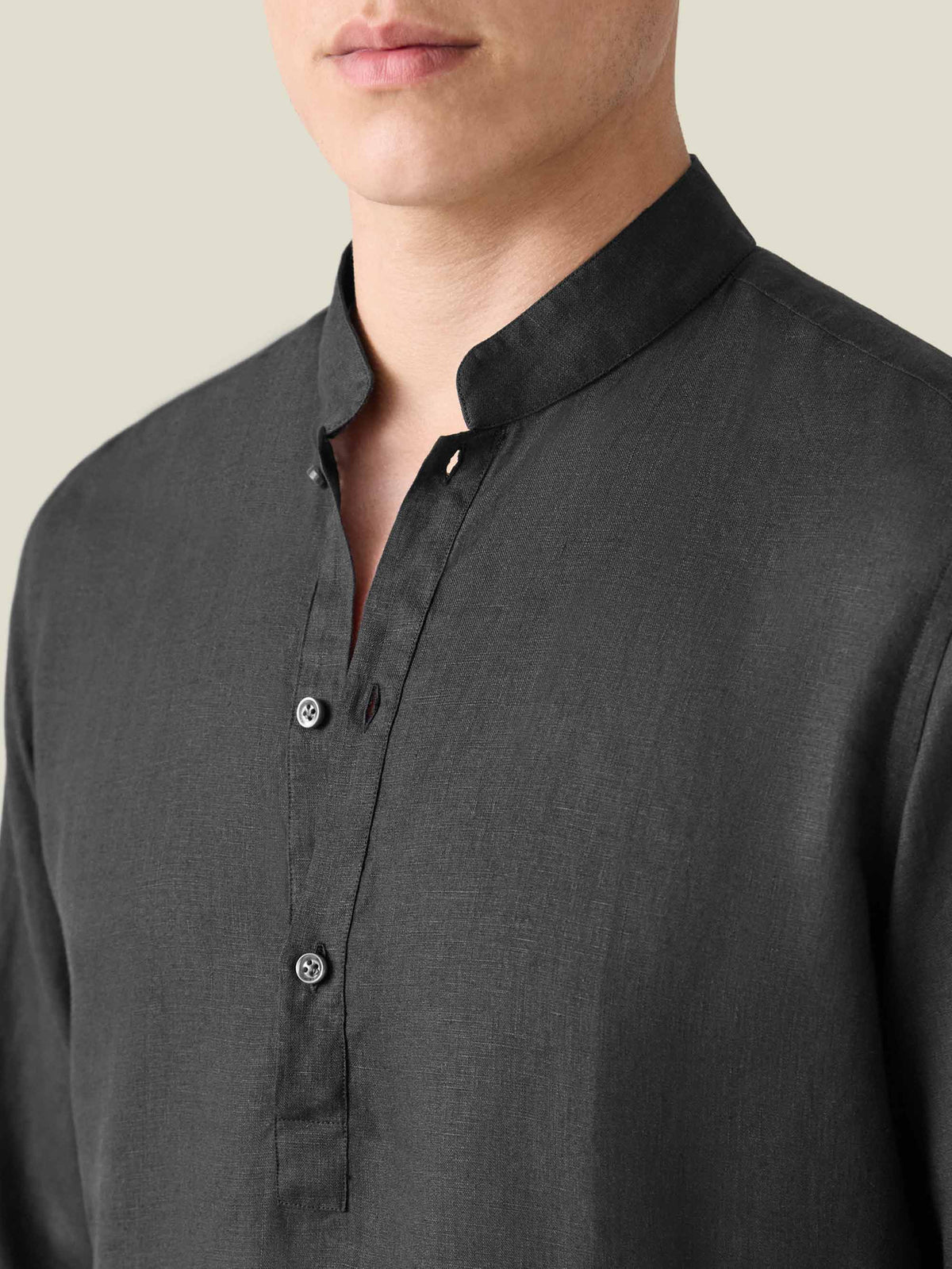 Close-up of a model wearing the Black Forte Linen Shirt, showing the band collar and mother of pearl button details.