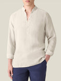 Man wearing the Forte Linen Shirt in Sand. A front view showing the band collar, popover placket, and rolled-up long sleeves.