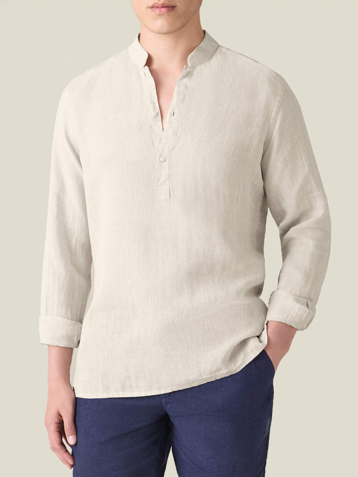 Man wearing the Forte Linen Shirt in Sand. A front view showing the band collar, popover placket, and rolled-up long sleeves.