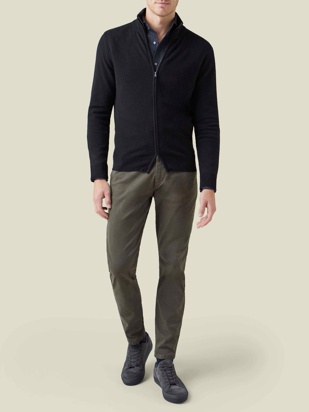 Model wears the black Brushed Cotton Shirt under a black zip cardigan, styled with olive trousers and dark grey sneakers.