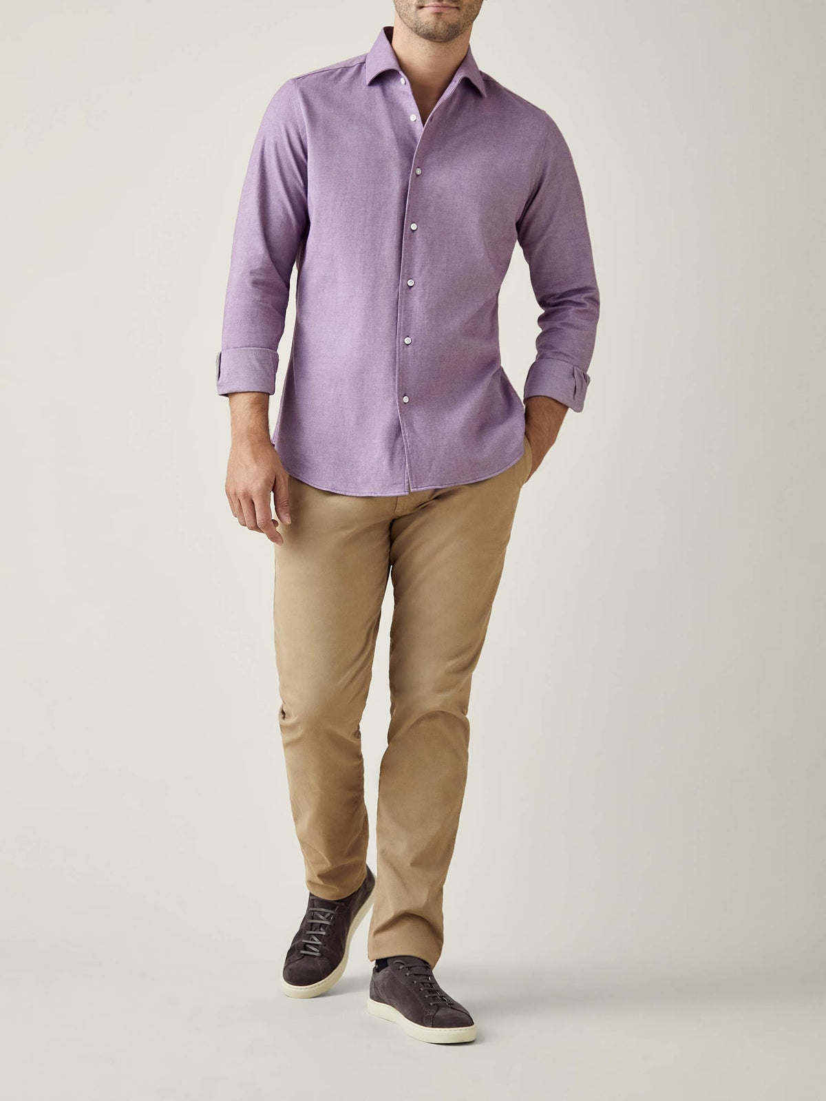 Full-length studio shot of a model wearing the Purple Brushed Cotton Shirt with beige chinos and dark grey trainers.