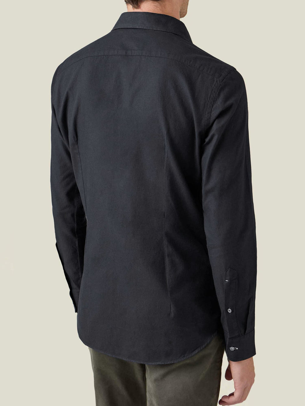 Back view of a model wearing the Black Brushed Cotton Shirt, showcasing its fit and rounded hemline.