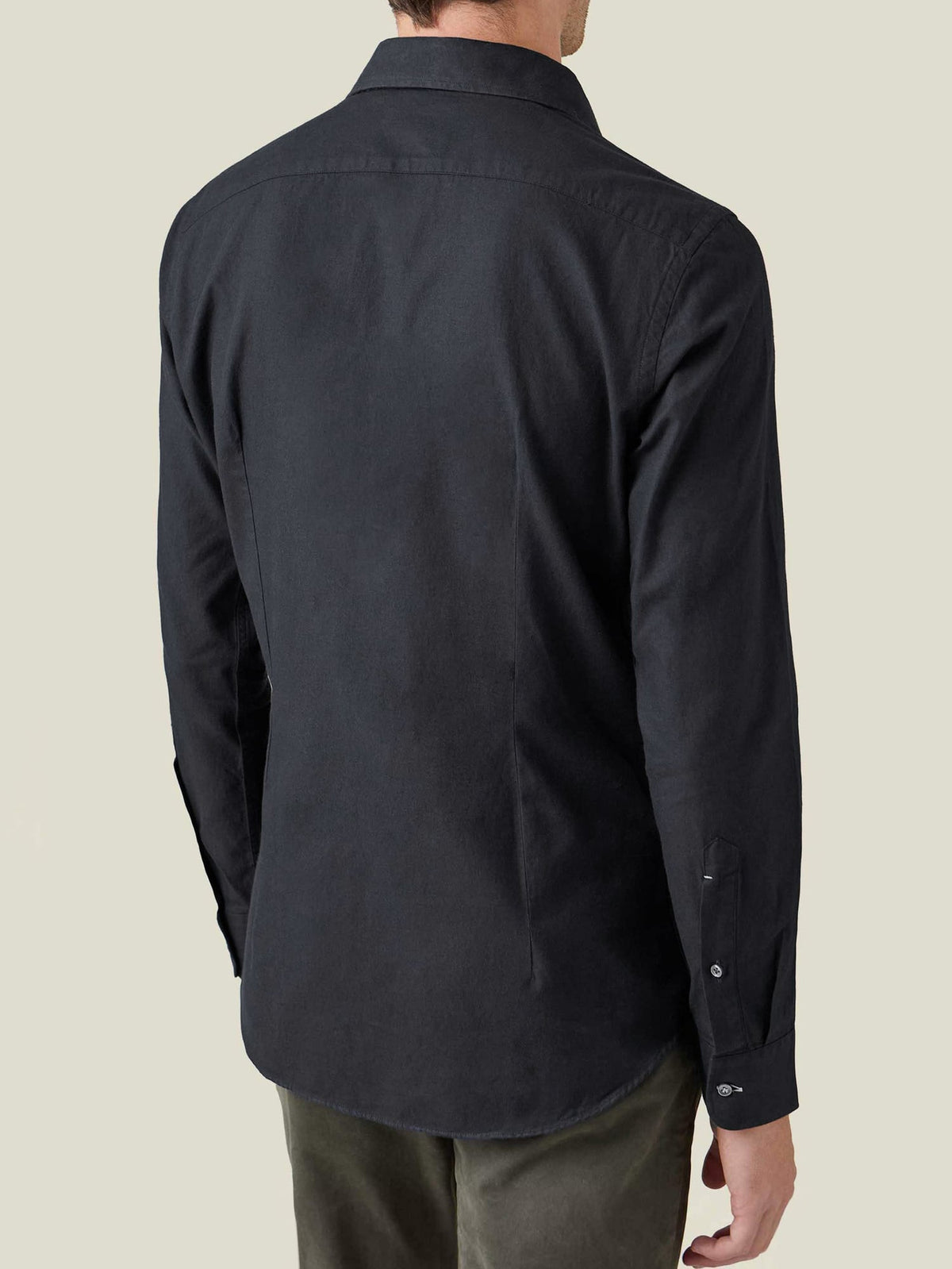 Back view of a model wearing the Black Brushed Cotton Shirt, showcasing its fit and rounded hemline.