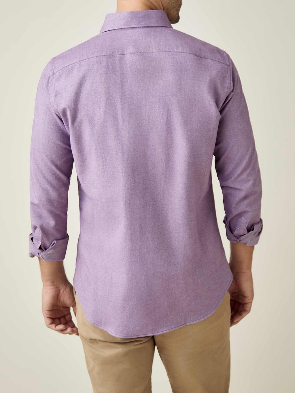Back view of a model wearing a purple Brushed Cotton Shirt with rolled-up sleeves, paired with beige trousers.