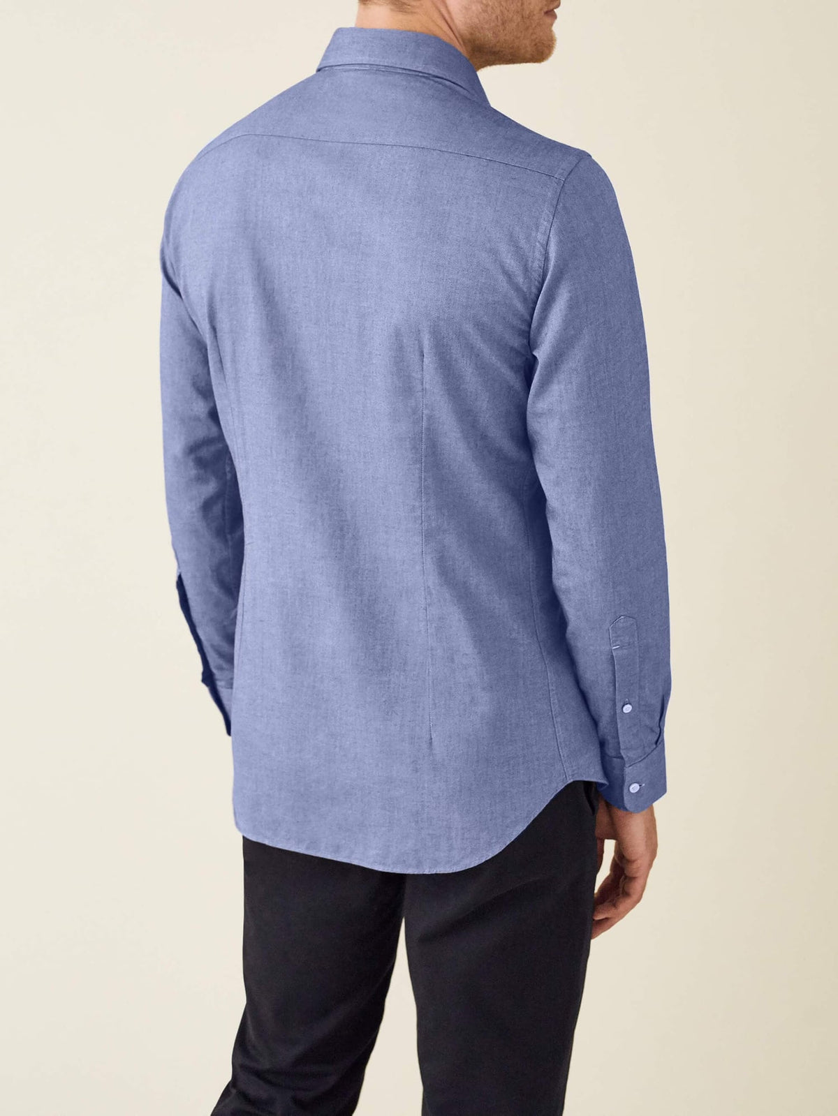 Back view of a model wearing the Luca Faloni Indigo Brushed Cotton Shirt, showcasing the slim fit and curved hemline.