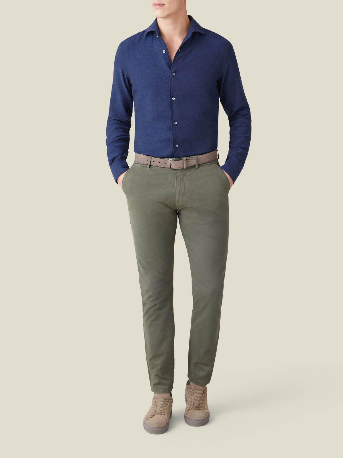 A model wears the Luca Faloni Navy Blue Cashmere-Cotton Shirt styled with olive green chinos and beige suede trainers.