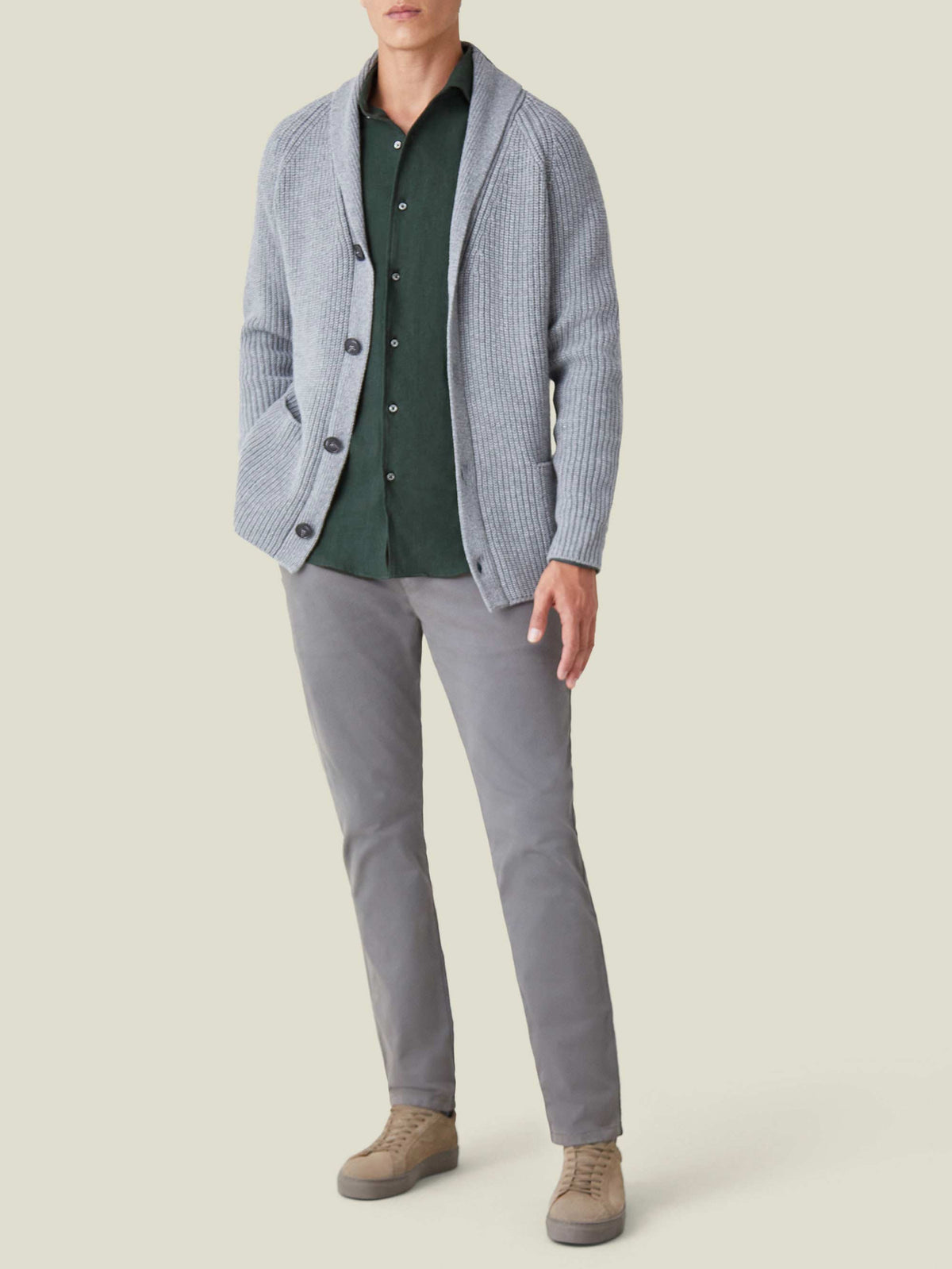 A model wears the Forest Green Cashmere-Cotton Shirt styled with a grey shawl cardigan, grey trousers, and beige sneakers.