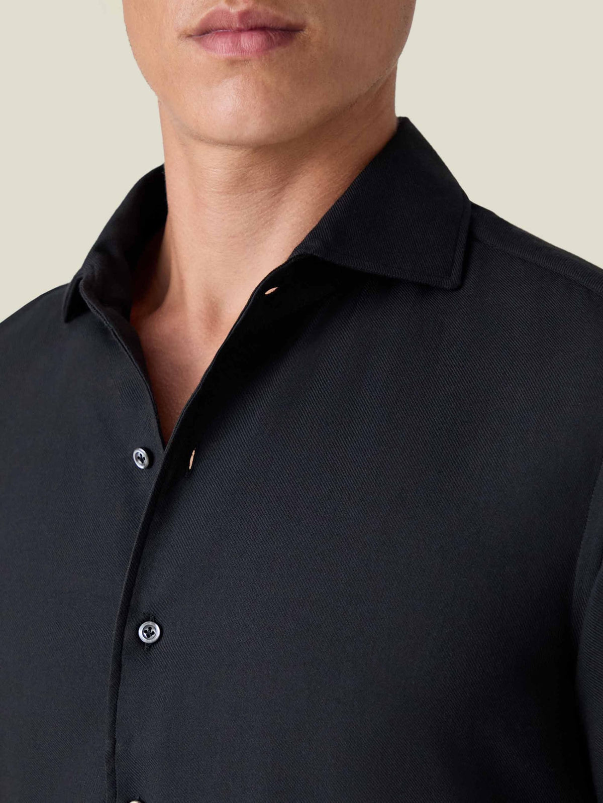 A close-up of a man wearing the Black Cashmere-Cotton Shirt, showing the signature one-piece collar and soft fabric.