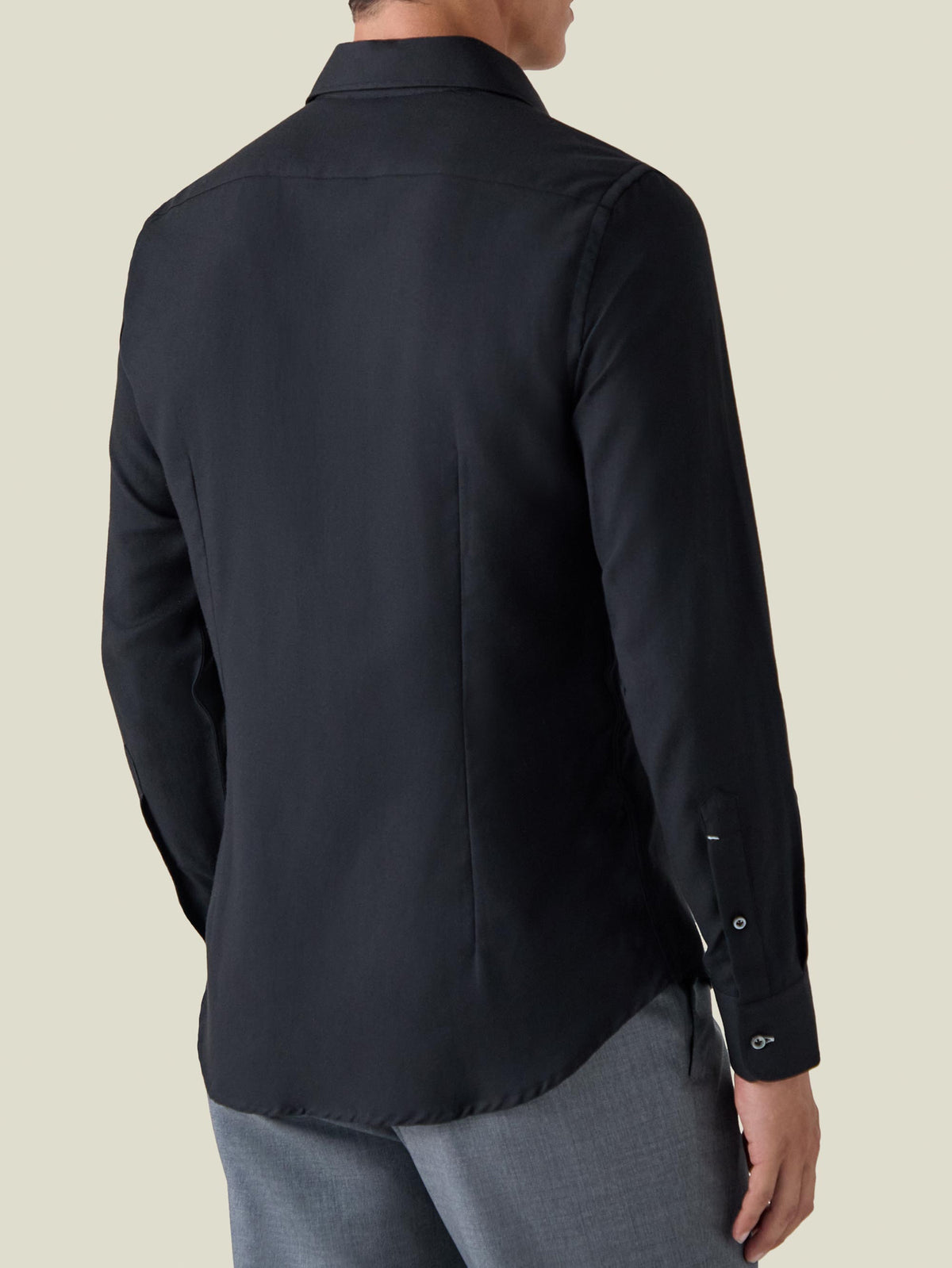 Back view of a model wearing the black Cashmere-Cotton Shirt, showcasing its slim fit, rounded hem, and soft texture.