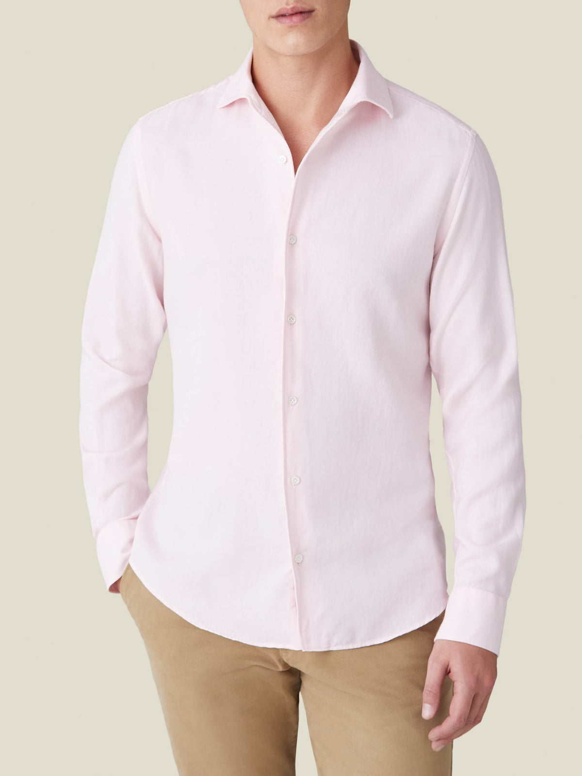 A front view of a model wearing the Luca Faloni Cashmere-Cotton Shirt in Light Pink with brown trousers.