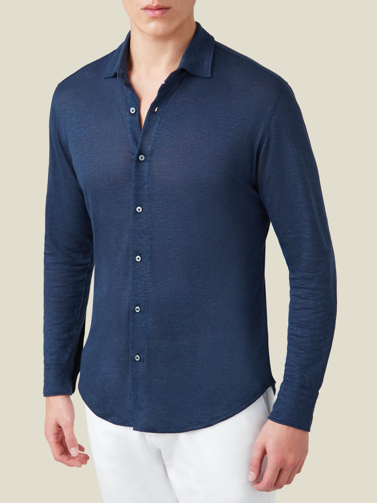Front view of a model wearing the navy blue Linen Jersey Shirt by Luca Faloni, paired with white trousers.