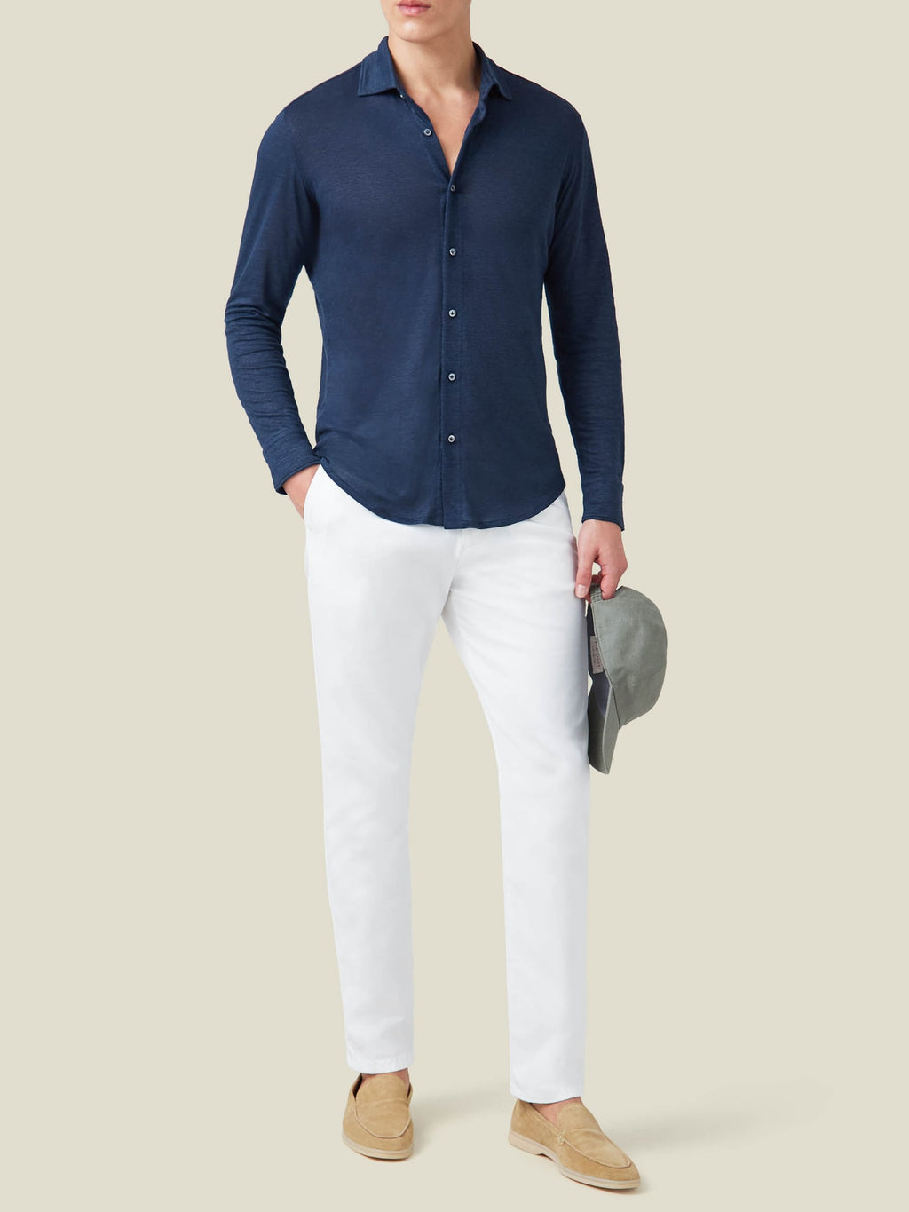 Model seen from the front wearing the navy blue Linen Jersey Shirt with white trousers and beige loafers.