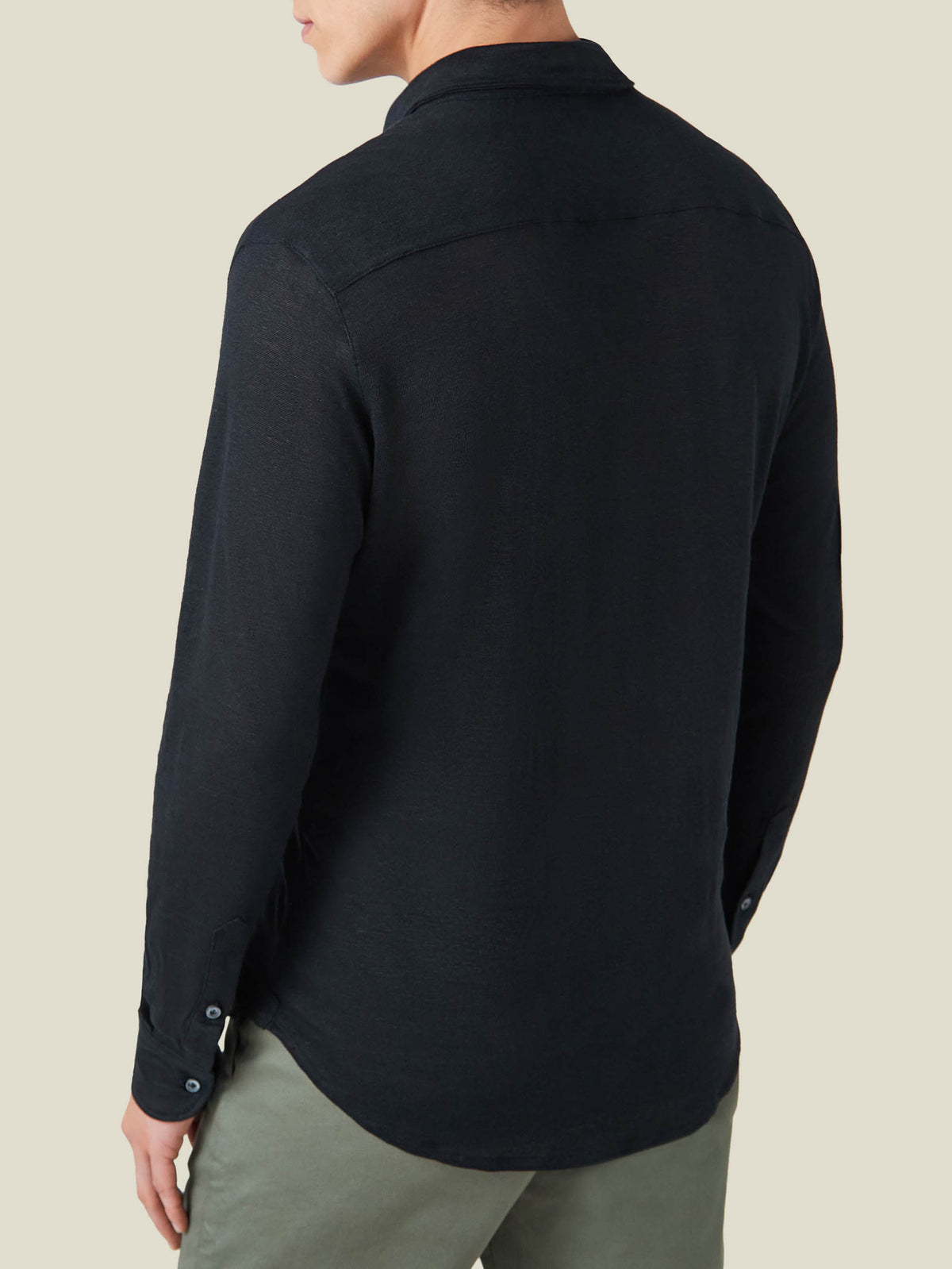 Back view of a model wearing the Black Linen Jersey Shirt, highlighting the shirt's relaxed fit and soft texture.