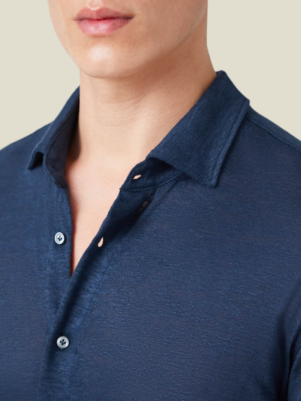 Close-up of a model wearing the navy blue Linen Jersey Shirt, showing the detail of the cutaway collar and textured fabric.