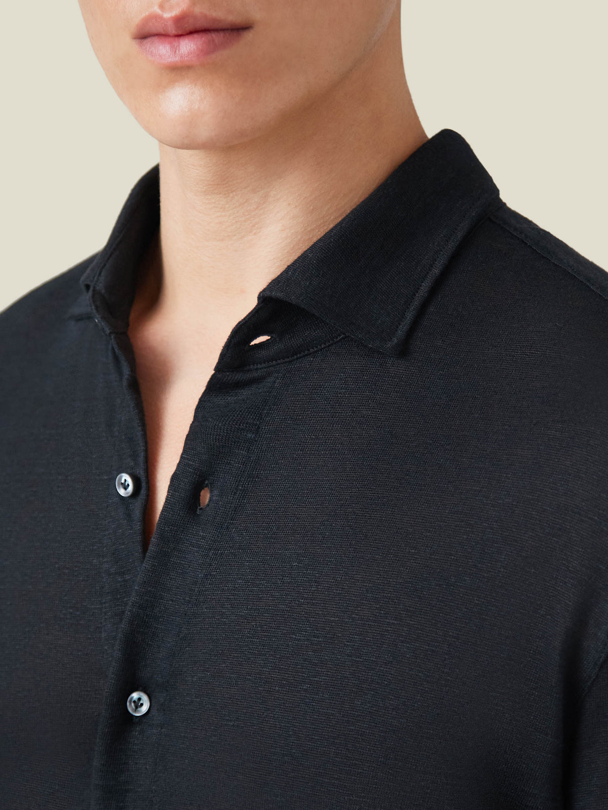 Close-up of the black Linen Jersey Shirt, showing the soft textured fabric, cutaway collar, and mother-of-pearl buttons.