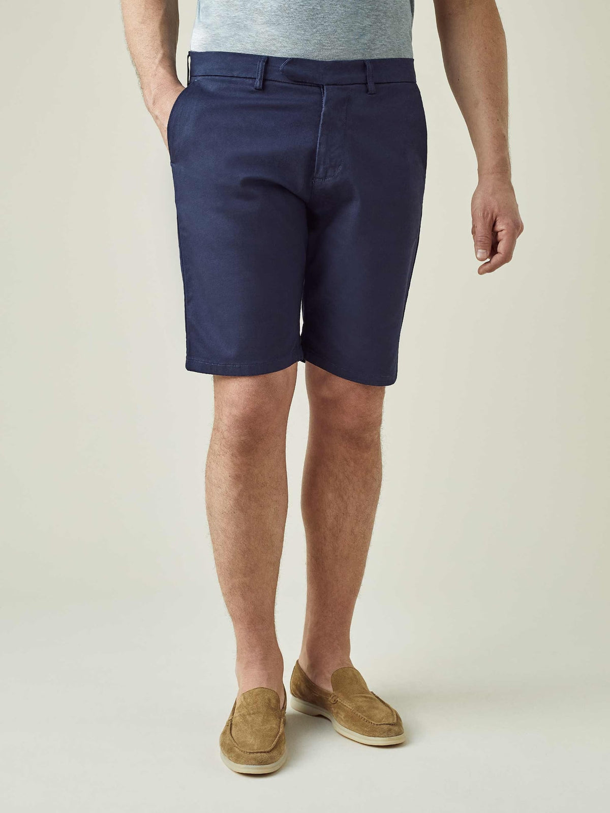 A front view of a model wearing the Luca Faloni Cotton Shorts in Navy Blue with tan suede loafers.