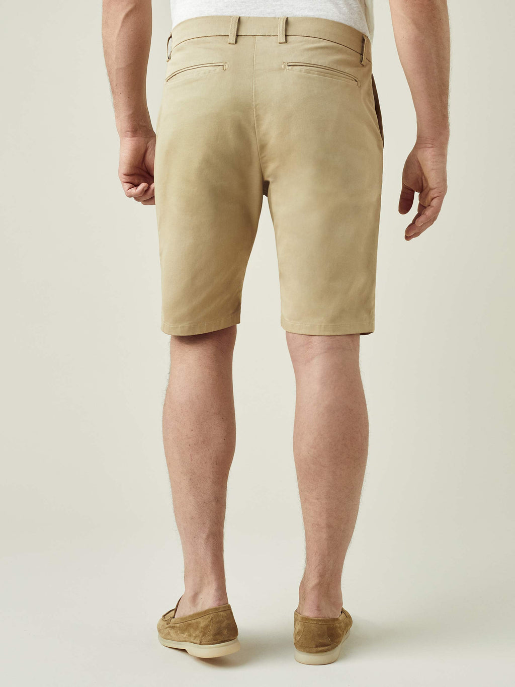 Rear view of a model wearing Luca Faloni's Cotton Shorts in Camel Beige, showcasing the slim fit and back pocket details.