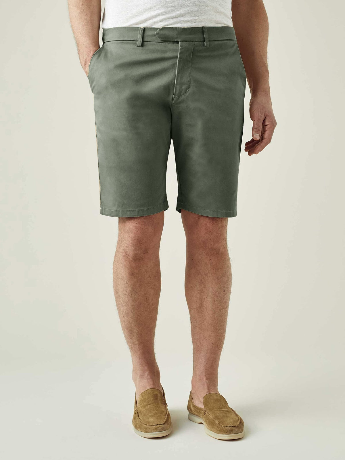A front view of a model wearing the Luca Faloni Cotton Shorts in Olive Green with a light grey t-shirt and tan loafers.