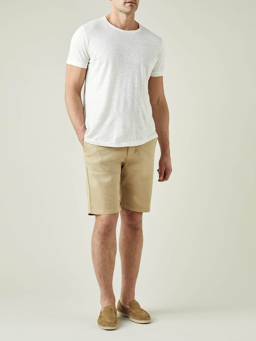 Front view of a model wearing Luca Faloni's Camel Beige Cotton Shorts with a white t-shirt and tan suede loafers.