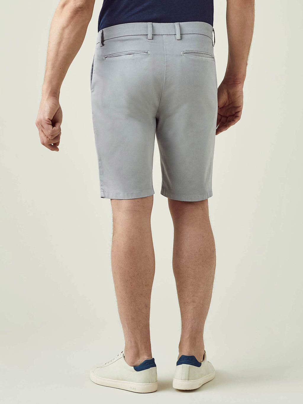 Model from behind wearing Luca Faloni's light grey Cotton Shorts, showcasing the tailored fit and sleek back pocket design.