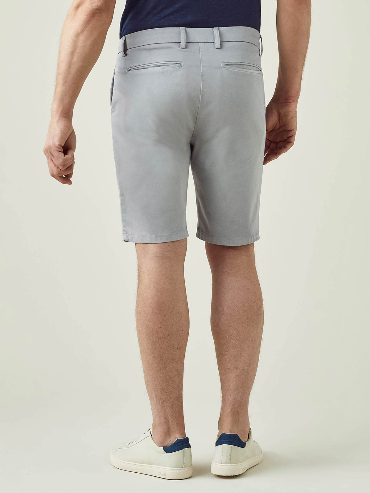 Model from behind wearing Luca Faloni's light grey Cotton Shorts, showcasing the tailored fit and sleek back pocket design.