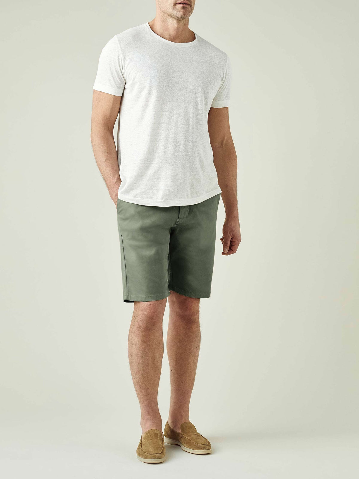 Full-length view of a model wearing Luca Faloni's Olive Green Cotton Shorts with a light grey t-shirt and tan suede loafers.