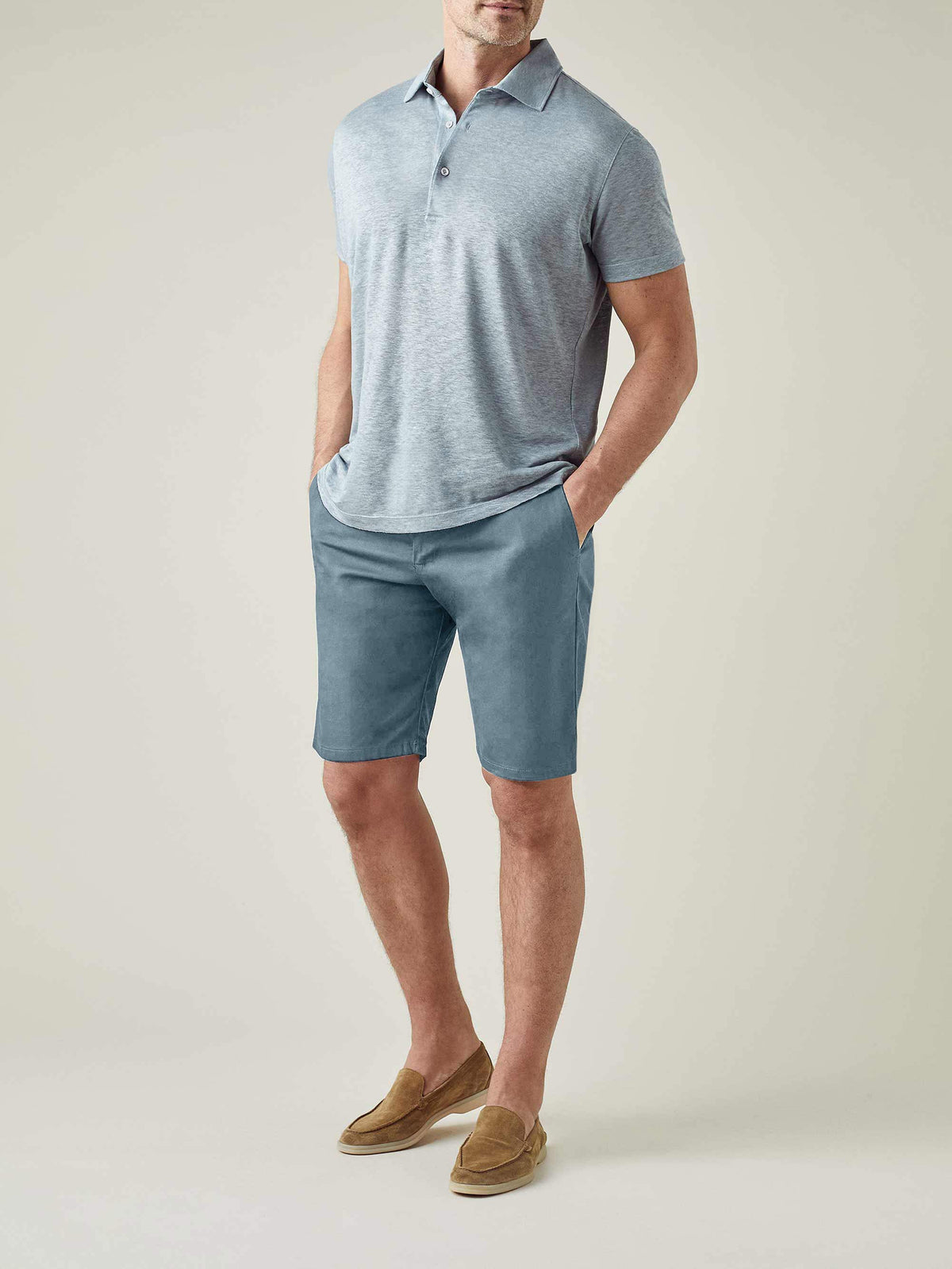 A model wears the Luca Faloni Light Blue Cotton Shorts with a grey polo shirt and tan suede loafers.