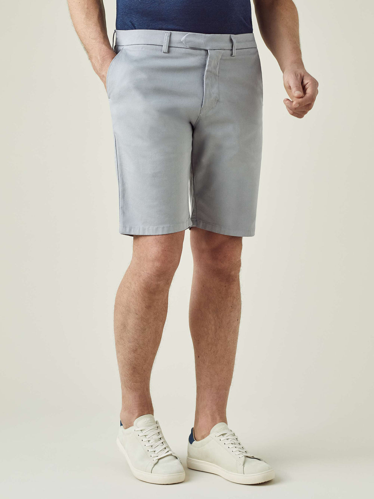 A front view of a model wearing the Luca Faloni Light Grey Cotton Shorts, styled with a navy top and white sneakers.
