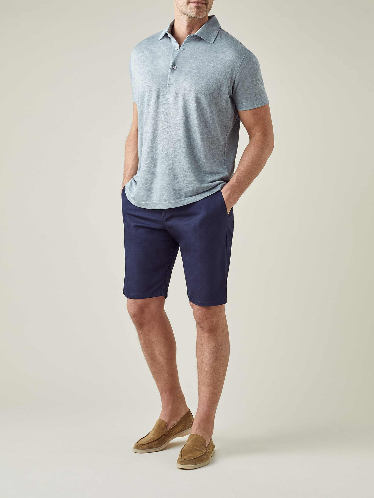 A model wearing Luca Faloni's Navy Blue Cotton Shorts, styled with a light blue polo shirt and tan suede loafers.