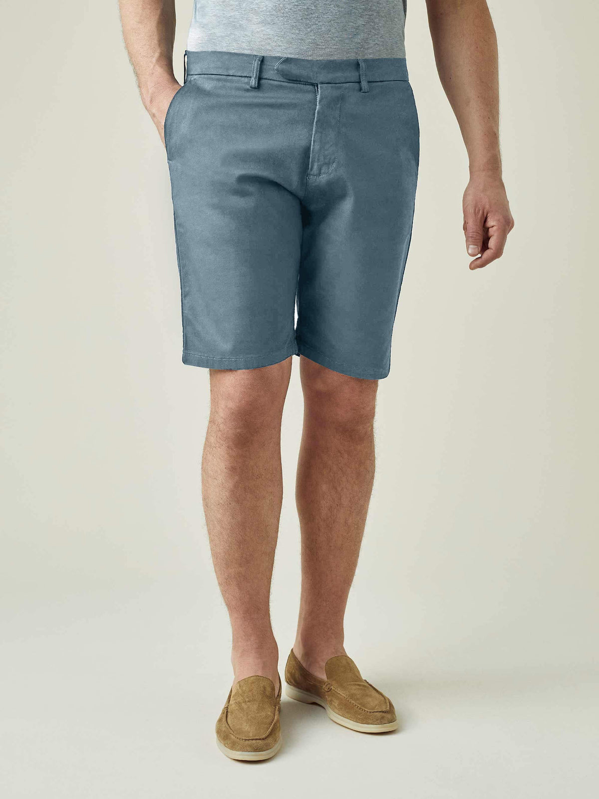 Front view of a model wearing Luca Faloni's Light Blue Cotton Shorts with a grey t-shirt and brown suede loafers.