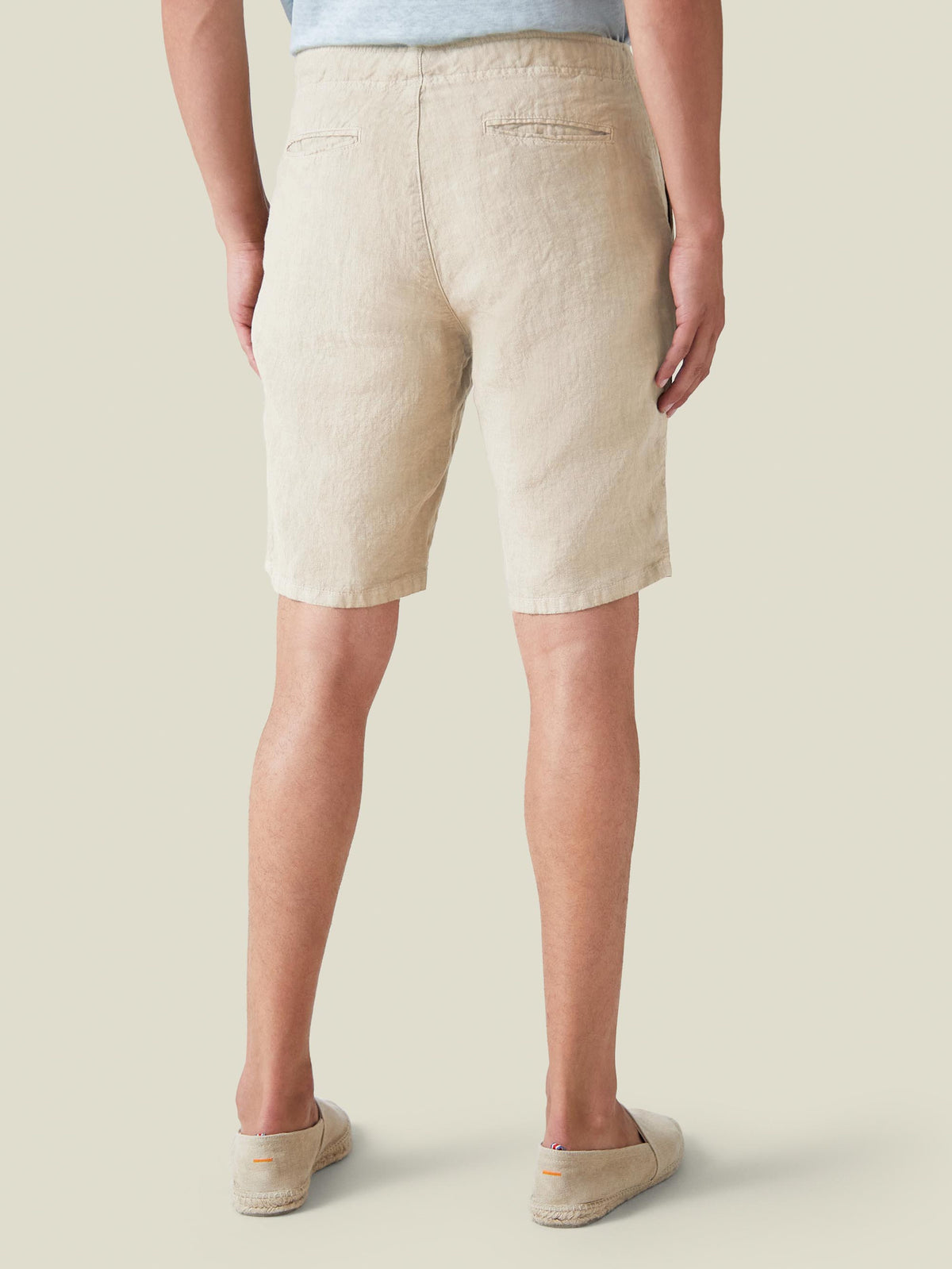 Back view of a model wearing the Luca Faloni Bermuda Linen Shorts in sand.