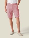 A model wears the Dusty Pink Bermuda Linen Shorts, paired with a white t-shirt and espadrilles, against a studio background.