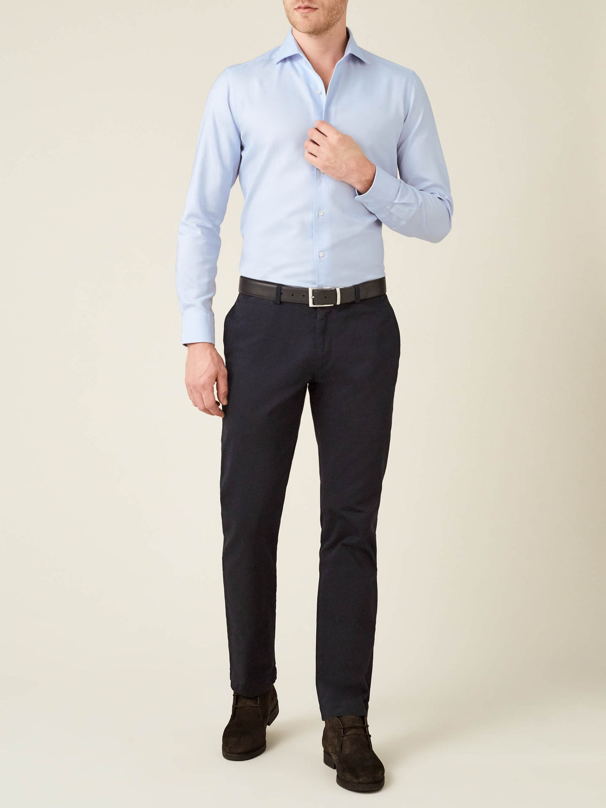 A model wears the Luca Faloni Light Blue Oxford Cotton Shirt with dark trousers, a black belt, and brown suede shoes.