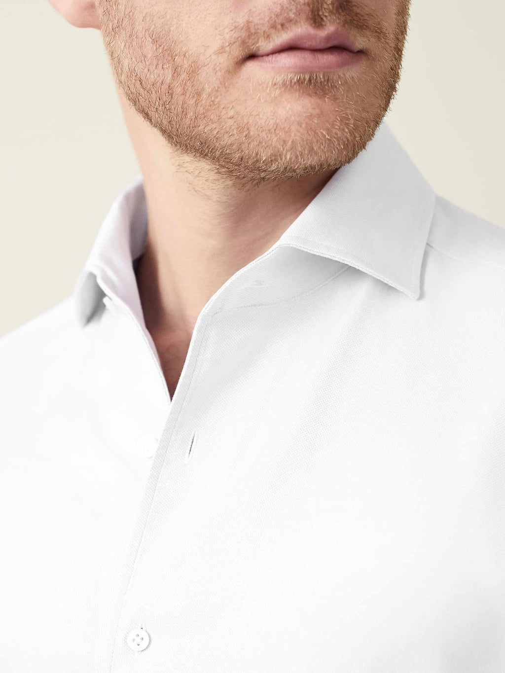 Detail shot of a man wearing the white Oxford Cotton Shirt, focusing on the signature one-piece collar.