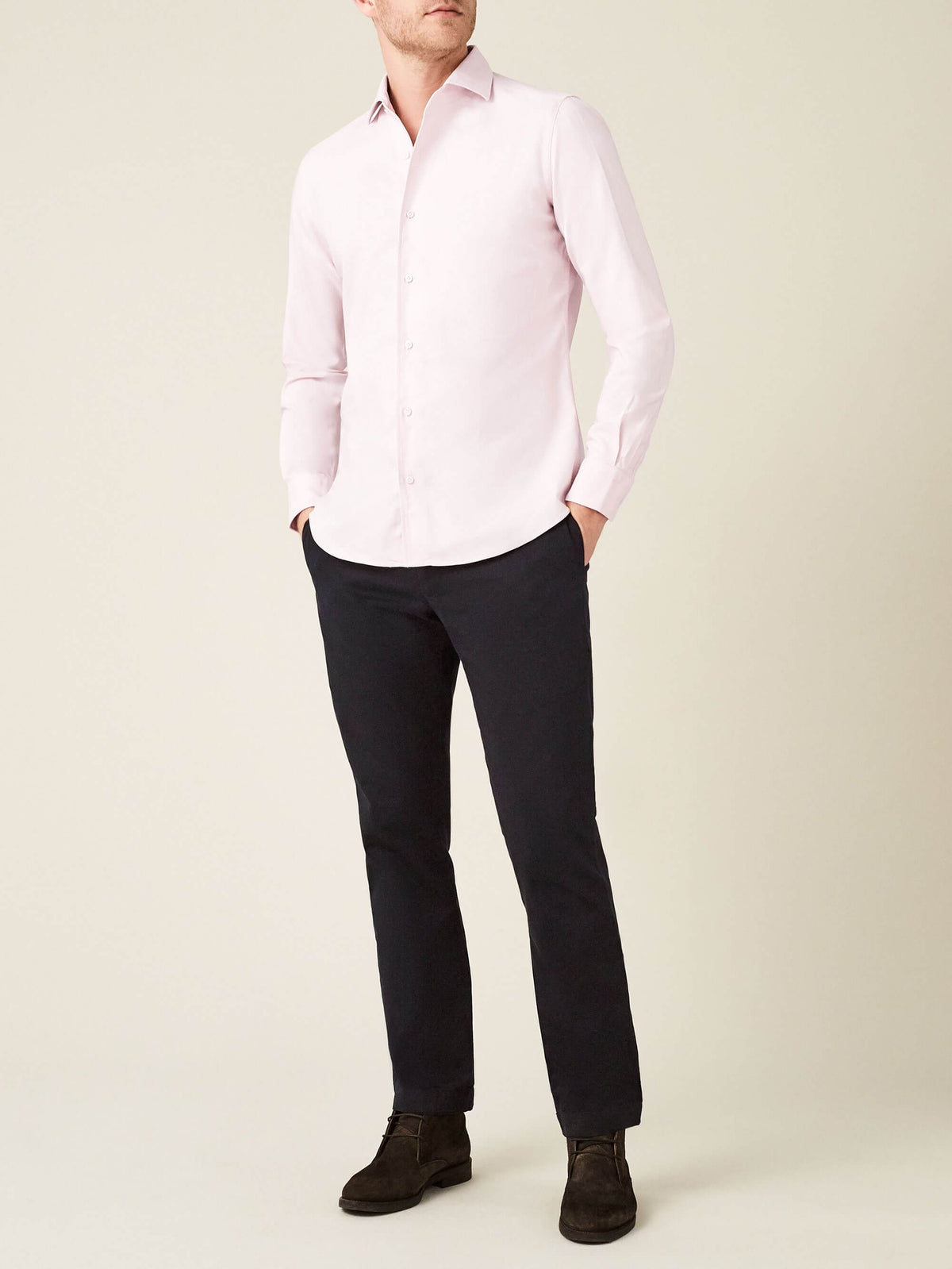 A full-length view of a model wearing the Luca Faloni Light Pink Oxford Cotton Shirt with dark trousers and boots.