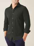 Front view of a model wearing the Siena Piqué Shirt in Forest Green with the sleeves casually rolled up.